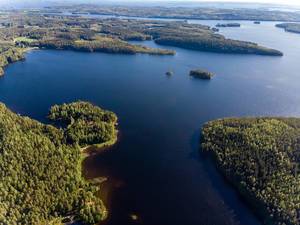 Drone picture shows lake district in Finland, with green forest areas and untouched nature around Padasjoki