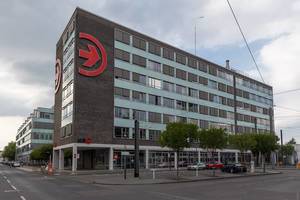 E-Ladestation am Kölner Verkehrsunternehmen:  Bürohaus der KVB mit großem, roten Logo an der Hauswand