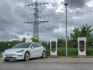 E-Mobilty: White electric car Tesla Model 3 at a Supercharging-Station in Erftstadt, Germany