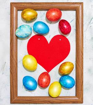 Easter concept. Colorful easter eggs placed in the wooden picture frame