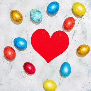 Easter concept. Easter eggs and a big paper red heart
