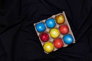 Easter concept. Painted easter festive eggs on the dark textile (Flip 2020)