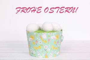 Easter eggs in a basket and Frohe Ostern text