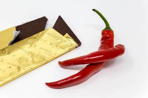 Edel-Zartbitter Schokolade im goldener Verpackung mit zwei Chili Schoten