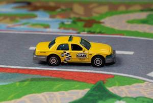 Ein gelbes Taxi fährt auf der Straße - Modelauto