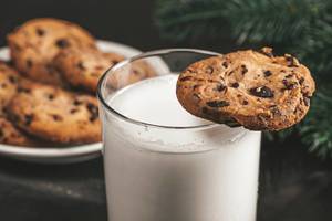 Ein Glas warme Milch mit Schokoladen Keksen zu Weihnachten