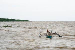 Ein kleines, einfaches Fischerboot ankert aufgrund schlechtem Wetter in Balaring, Silay