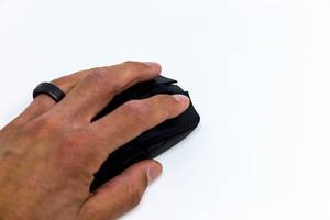 Ein Mann benutzt die Razer Viper Ultimate Wireless Gaming Maus: Nahaufnahme von Hand und Maus vor weißem Hintergrund