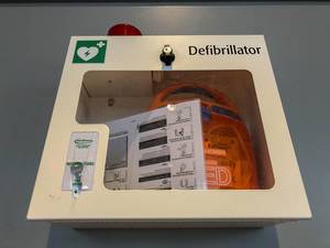 Ein Notfall Defibrillator in einem Sicherheitskasten an einer Wand