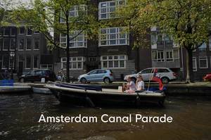 Ein Paar im Motorboot auf den Amsterdamer Grachten, neben dem Bildtitel Amsterdam Canal Parade, die Teil des Gay Pride - LGBT - Festivals ist