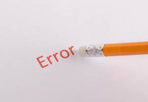 Ein Radiergummi auf einem Bleistift radiert das rote Wort Error auf weißem Hintergrund