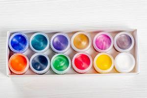 Ein Set von bunten Farben für Malen auf braunem Holztisch