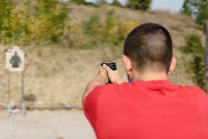 Ein Sportschütze schießt mit einer Pistole auf eine Zielscheibe
