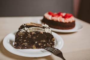 Ein Stück Schokoladenkuchen auf einem weißen Teller mit einer Gabel