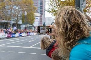 Eine Dame nimmt den Frankfurter Marathon auf mit ihrem Smartphone