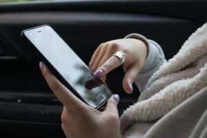 Eine Frau benutzt Smartphone im Auto