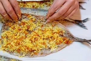 Eine Frau füllt eine Makrele mit Käse