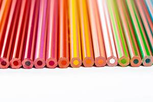Eine große Auswahl an ungespitzten Buntstiften in verschiedenen Farben, auf weißem Oberfläche