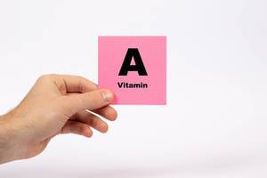 Eine Notiz mit der Aufschrift Vitamin A in der Hand gehalten auf weißem Hintergrund