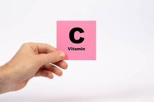 Eine Notiz mit der Aufschrift Vitamin C in der Hand gehalten auf weißem Hintergrund