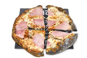 Eine Prosciutto-Pizza mit schwarzem Boden dank Aktivkohle
