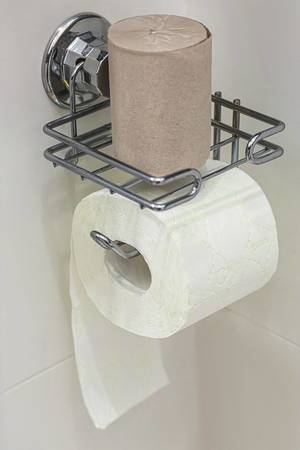 Eine Rolle weißes Toilettenpapier mit Toilettenpapierhalter aus Metall
