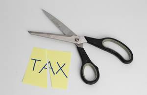 Eine Schere zerschneidet zu hohe Steuern - TAX