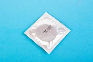 Eingepacktes Kondom auf blauem Hintergrund