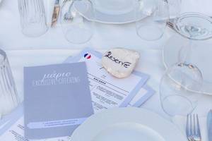 Elegant gedeckter, mediterraner Tisch mit Speisekarte und Stein mit Aufschrift „RESERVE“