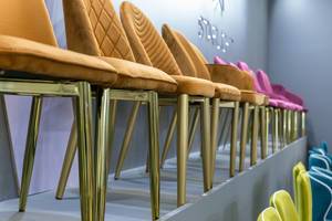 Elegante Stühle mit goldenen Stuhlbeinen und bequemen Sitzflächen mit Struktur