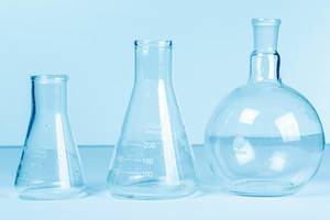 Empty flasks on a light blue background. Laboratory glassware