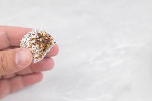 Energy Balls with Coconut in the hand with copy space