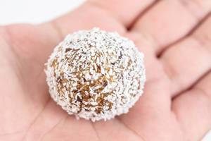Energy Balls with Date Palm fruits Almonds Walnuts and Coconut in the hand