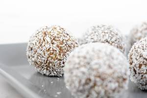 Energy Balls with Date Palm fruits Almonds Walnuts and Coconut on the plate