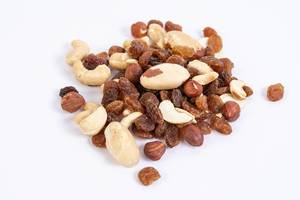 Energy mix with raisins hazelnuts cashew and brazilian nuts above white background