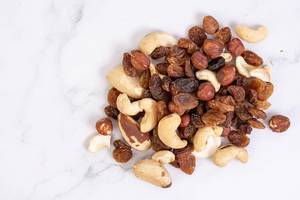 Energy mix with raisins hazelnuts cashew and brazilian nuts on the marble table