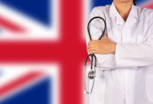 Englisches Gesundheitssystem symbolisiert durch die Nationalflagge und eine Ärztin mit Stethoskop in der Hand