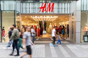Entrance and Store Front of H&M Shop with Pedestrians walking past