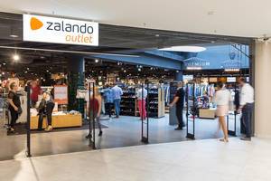 Entrance of a Zalando Outlet Store with People walking around