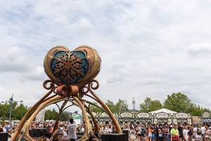 Entrance of Tomorrowland festival: DJ plays music in a futuristic DJ stage with a huge heartshaped installation on the top