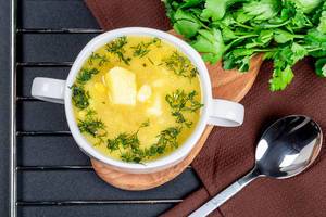 Erbsensuppe mit Kartoffeln und Dill in einer Suppentasse mit Löffel und frischem Dill von oben fotografiert