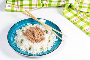 Essstäbchen neben einem Reisteller mit Tunfisch