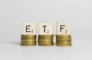 ETF exchange traded fund on the stacks of golden coins