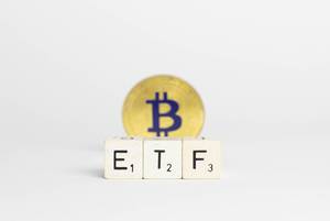 ETF Würfel-Schrift  - Investmentfonds mit einem Bitcoin auf weißem Hintergrund