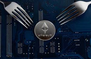 Ethereum coin with forks on motherboard