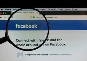 Facebook logo on a computer screen with a magnifying glass