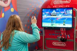 Fair visitor playing Mario Tennis Aces for Nintendo Switch
