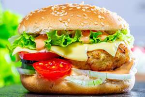 Fast food. A big burger with cutlet, cheese and vegetables (Flip 2019)