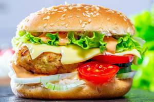 Fast food. A big burger with cutlet, cheese and vegetables