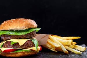 Fast food concept-French fries and hamburger on black background (Flip 2019)